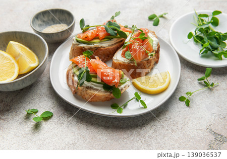 Salmon avocado toasts with microgreens and lemon 139036537