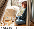 Child and dog bonding by window at home 139036555
