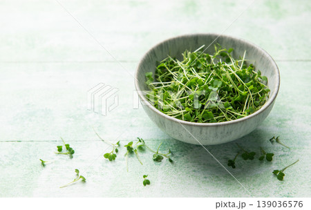 Fresh microgreens in a bowl on wooden surface 139036576