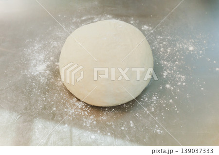 Raw fresh yeast dough ball for bread or pizza in kitchen counter with flour dust. 139037333