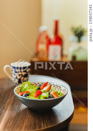 Healthy fresh salad with green lettuce strawberries and blueberries in a ceramic bowl. Healthy fresh salad with green lettuce strawberries and blueberries in a ceramic bowl. 139037342