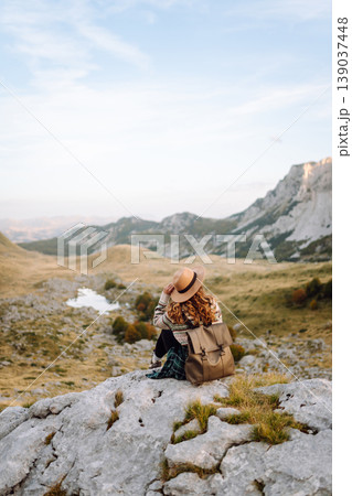 Happy woman stands on rocky terrain, gazing out at breathtaking landscape before her. Lifestyle. Happy woman stands on rocky terrain, gazing out at breathtaking landscape before her. Lifestyle. 139037448