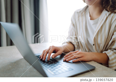 Close-up of woman's hands with modern laptop, studying, taking notes on device. Technology concept. Close-up of woman's hands with modern laptop, studying, taking notes on device. Technology concept. 139037820