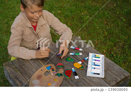 Flat stones become his canvas, and fruits and veggies become his art. A colorful masterpiece in the making. Flat stones become his canvas, and fruits and veggies become his art. A colorful masterpiece in the making. 139038093