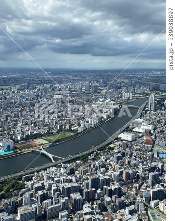 大都市を流れる大河と街並みの俯瞰パノラマ、雲流れる空が広がる都市の水辺風景 大都市を流れる大河と街並みの俯瞰パノラマ、雲流れる空が広がる都市の水辺風景 139038897
