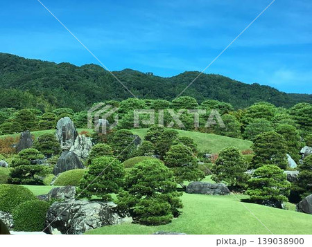 青空に映える日本庭園と山の稜線、巨石と庭木が美しい和の風景 青空に映える日本庭園と山の稜線、巨石と庭木が美しい和の風景 139038900