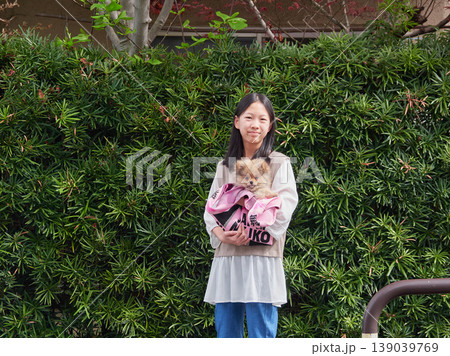 春の公園で可愛いポメラニアンの子犬を連れて遊んでいる女子中学生の姿 春の公園で可愛いポメラニアンの子犬を連れて遊んでいる女子中学生の姿 139039769