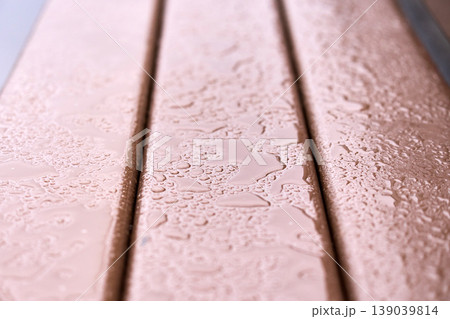 Symbol of loneliness and peace: An empty wet bench in a public park, shallow depth of field 139039814