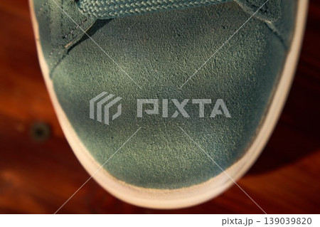 Detailed shot of teal shoe. Closerange photograph highlighting fine nap texture and precise stitching on teal sneaker Detailed shot of teal shoe. Closerange photograph highlighting fine nap texture and precise stitching on teal sneaker 139039820