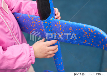 Little child touching colorful upholstery. Young child in vibrant attire explores patterned fabric of public transit seat 139039860