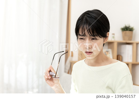 眼精疲労で目頭を押さえ、眼鏡を外して休息する日本人女性 139040157