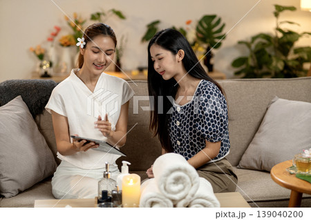 Asian women therapist client spa consultation tablet discussion cozy wellness center Asian women therapist client spa consultation tablet discussion cozy wellness center 139040200