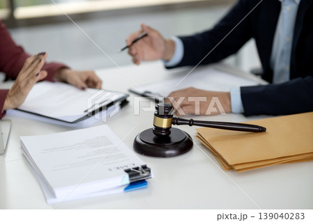 Adult legal professionals client meeting discussing important case documents justice advice at law office court room table for agreement resolution 139040283