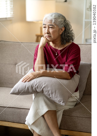 Older Asian woman sit sofa deep thought worry sadness contemplating life problems mental health challenges lonely retirement senior distress contemplation solitude Older Asian woman sit sofa deep thought worry sadness contemplating life problems mental health challenges lonely retirement senior distress contemplation solitude 139040382