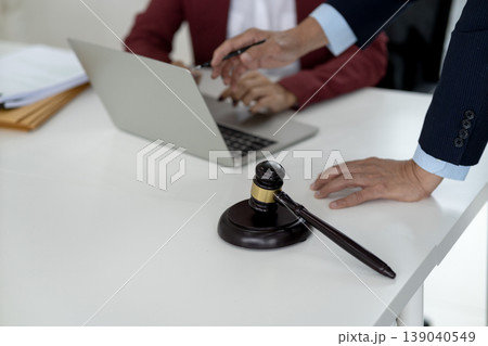 Asian legal professionals adults consult on a case review documents using laptop a law firm office with judge gavel justice concept Asian legal professionals adults consult on a case review documents using laptop a law firm office with judge gavel justice concept 139040549