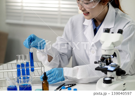 Asian woman scientist conduct lab experiment chemistry research test tube analysis microscope discovery innovation medicine health development 139040597