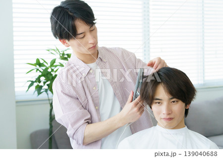ヘアアイロンで髪をカールする若い日本人美容師 ヘアアイロンで髪をカールする若い日本人美容師 139040688