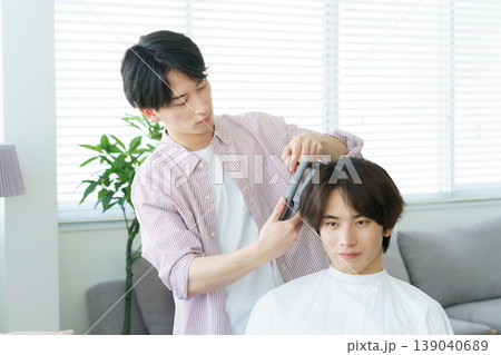 ヘアアイロンで髪をカールする若い日本人美容師 ヘアアイロンで髪をカールする若い日本人美容師 139040689