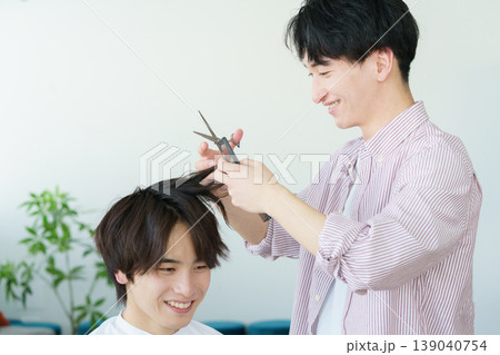 髪をカットする若い日本人美容師 139040754