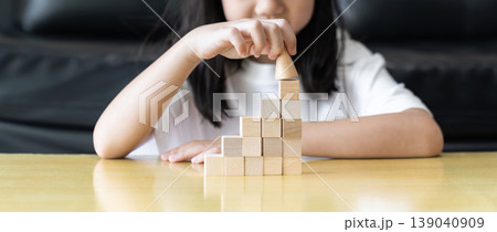 Wooden blocks rising steps child behind patience effort planning strategy step progress focus control consistency logical development achievement. Wooden blocks rising steps child behind patience effort planning strategy step progress focus control consistency logical development achievement. 139040909