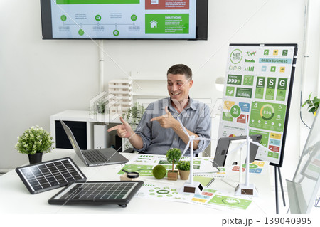 Adult Caucasian man discusses green business strategies sustainable energy solutions modern office showing ESG reports renewable technology consultant explaining eco friendly concepts corporate 139040995