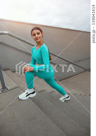 Fitness sport girl in fashion sportswear doing yoga fitness exercise in the street. Young woman training outdoors. Fitness sport girl in fashion sportswear doing yoga fitness exercise in the street. Young woman training outdoors. 139041614