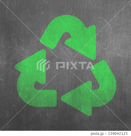 A vibrant green universal recycling symbol on a dark, rough-textured gray surface, representing environmental sustainability, waste reduction, and eco-friendly practices 139042125