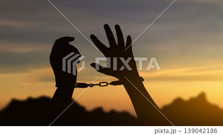 A powerful silhouette of human hands bound by handcuffs against a golden sunset sky, symbolizing themes of freedom, justice, incarceration, and human rights A powerful silhouette of human hands bound by handcuffs against a golden sunset sky, symbolizing themes of freedom, justice, incarceration, and human rights 139042186