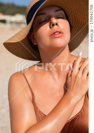 Pretty Woman Touching Shoulder With Eyes Closed At Beach. Beauty Skincare Concept. Female Relaxing Under Sunlight During Summer Vacation Pretty Woman Touching Shoulder With Eyes Closed At Beach. Beauty Skincare Concept. Female Relaxing Under Sunlight During Summer Vacation 139042706
