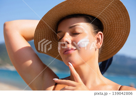 Attractive Woman Relaxing With Closed Eyes In Sunlight At Beach. Beauty Skincare Concept. Female Enjoying Summer Sun And Healthy Skin Attractive Woman Relaxing With Closed Eyes In Sunlight At Beach. Beauty Skincare Concept. Female Enjoying Summer Sun And Healthy Skin 139042806