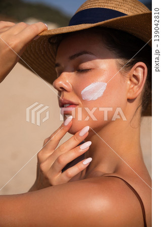 Beautiful Woman Applying Sunscreen On Face And Looking Sideways At Beach. Beauty Skincare Concept. Female Using Sun Cream 139042810