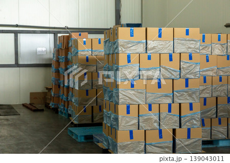 Stacks of cardboard boxes in industrial warehouse. Stacks of cardboard boxes in industrial warehouse. 139043011