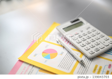 電卓とグラフが置かれた書類 139043703