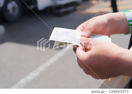 屋外イベントの屋台で買い物前に現金を用意する手元 屋外イベントの屋台で買い物前に現金を用意する手元 139043973