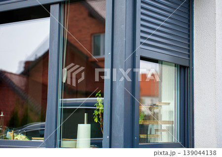 Residential window with partially closed roller shutter 139044138