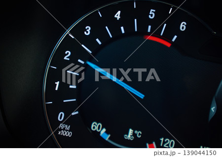 Close up of illuminated car tachometer on dashboard Close up of illuminated car tachometer on dashboard 139044150