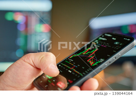 Smartphone with cryptocurrency trading chart in hand Smartphone with cryptocurrency trading chart in hand 139044164