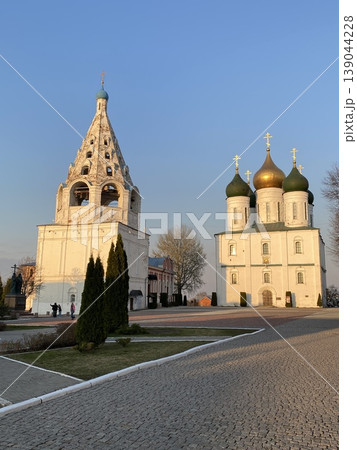 Orthodox church with golden domes and bell tower against clear blue sky in a vertical format 139044228