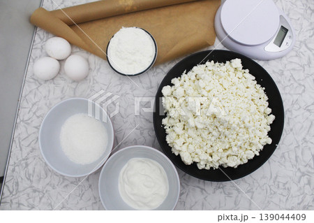 cottage cheese, sugar, eggs in bowls. Making a pie with cottage cheese cottage cheese, sugar, eggs in bowls. Making a pie with cottage cheese 139044409