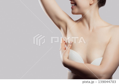 Skin care. Armpit epilation, laser hair removal. Young woman holding her arms up and showing clean underarms, Skin care. Armpit epilation, laser hair removal. Young woman holding her arms up and showing clean underarms, 139044783