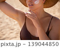 Attractive Woman Applying Sunscreen On Neck At Beach. Beauty Skincare And Sun Protection Concept. Female Using Sun Cream Lotion For Summer Skin Care 139044850