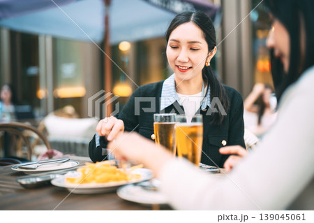 Two young adult asian business women enjoy eating dinner together on night at restaurant Two young adult asian business women enjoy eating dinner together on night at restaurant 139045061