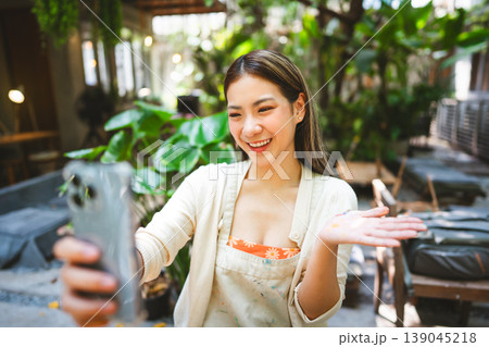 Gen Z Influencer content creator woman using smartphone with creativity painting at workshop cafe Gen Z Influencer content creator woman using smartphone with creativity painting at workshop cafe 139045218