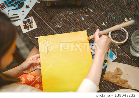 Woman painting brush yellow color on canvas art therapy creativity leisure 139045232