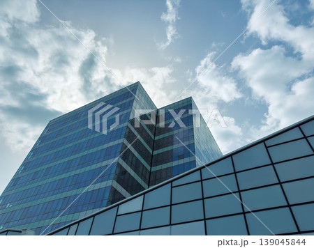 Business district has glass buildings under clouds with blue sky during the daytime 139045844