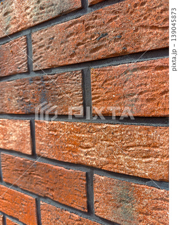 Close-up view of a brick wall showing the texture and color of the bricks during daylight in an urban setting Close-up view of a brick wall showing the texture and color of the bricks during daylight in an urban setting 139045873