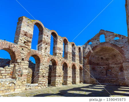 Exploring ancient ruins with stone arches under a blue sky during daylight hours in a historical location Exploring ancient ruins with stone arches under a blue sky during daylight hours in a historical location 139045973