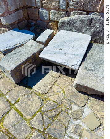Ancient stones form a section of a historical site in daylight at an outdoor location near ruins with a stone path Ancient stones form a section of a historical site in daylight at an outdoor location near ruins with a stone path 139045978