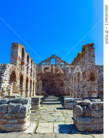 Ancient stone ruins stand under a clear blue sky in a historic location with visible arches and walls from past architecture Ancient stone ruins stand under a clear blue sky in a historic location with visible arches and walls from past architecture 139045980