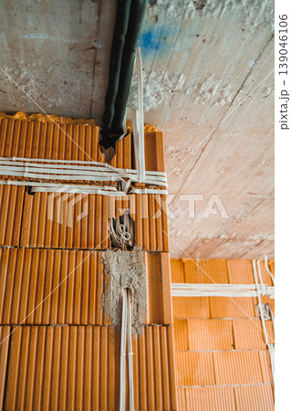 Wiring and construction details in a building with visible electrical cables and wall texture during renovation work 139046106